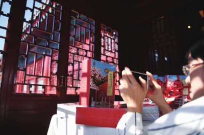 1月21日，一位女士在发布会上拍摄《哇！故宫的二十四节气》新书。□新华社照片