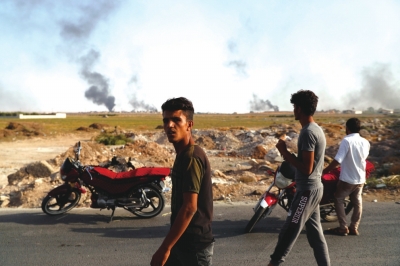 人们观看叙利亚境内遭袭后冒出的浓烟　□新华社照片